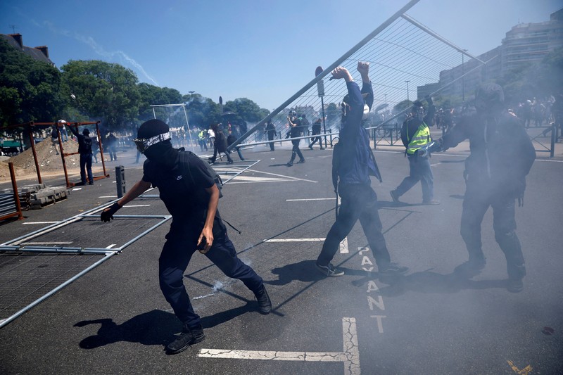 FRANCE-PROTESTS/ A masked prostester holds a red flare during clashes at a demonstration as part of the 14th day of nationwide protests against French government's pension reform law, in Nantes, France, June 6, 2023. REUTERS/Stephane Mahe