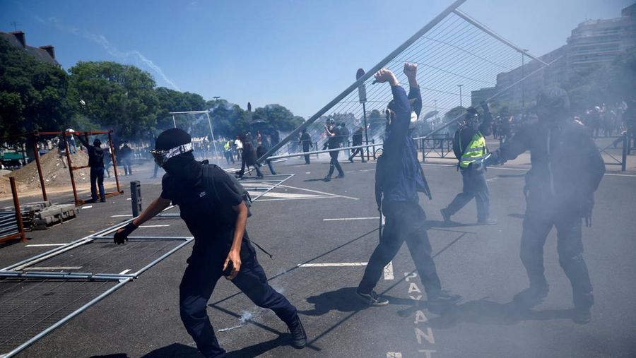 A masked prostester holds a red flare during clashes at a demonstration as part of the 14th day of nationwide protests against French government's pension reform law, in Nantes, France, June 6, 2023.  REUTERS/Stephane Mahe