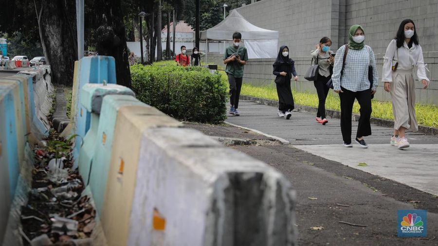 Sejumlah pejalan kaki melintasi trotoar di depan kantor Kedutaan Besar Amerika Serikat (Kedubes AS) di Jalan Merdeka Selatan, Jakarta, Rabu (7/6/2023). (CNBC Indonesia/Faisal Rahman)