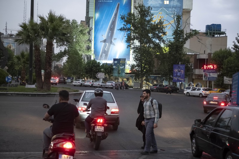 1258527747 An Iranian couple walk past a giant image of Fattah, Iran's first-ever hypersonic missile, in Palestine square in downtown Tehran, June 7, 2023. According to Iran's state media, the Fattah solid fuel hypersonic missile can reach Tel Aviv in 400 seconds from inside Iran and travels at a speed of 5,145 meters per second. (Photo by Morteza Nikoubazl/NurPhoto via Getty Images)