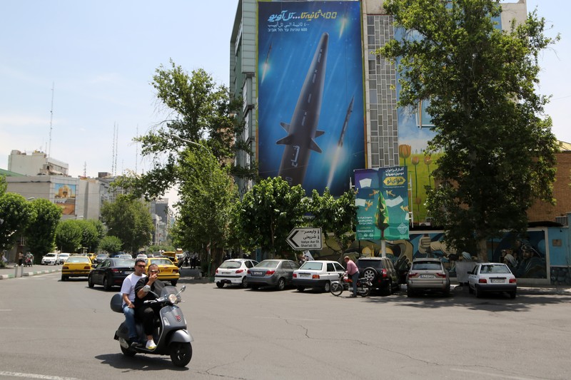 1258527747 An Iranian couple walk past a giant image of Fattah, Iran's first-ever hypersonic missile, in Palestine square in downtown Tehran, June 7, 2023. According to Iran's state media, the Fattah solid fuel hypersonic missile can reach Tel Aviv in 400 seconds from inside Iran and travels at a speed of 5,145 meters per second. (Photo by Morteza Nikoubazl/NurPhoto via Getty Images)