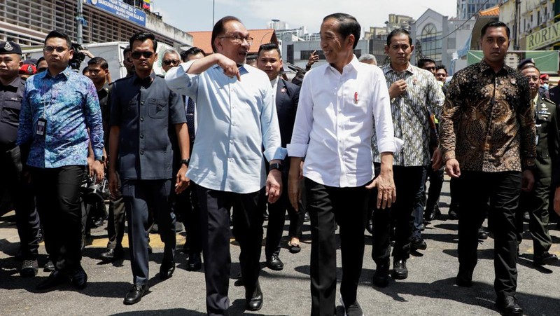 Joko Widodo, Indonesia's president, center, and Anwar Ibrahim, Malaysia's prime minister, center left, visit a wet market in Kuala Lumpur, Malaysia, on Thursday, June 8, 2023. Malaysia and Indonesia resolved the yearslong maritime border disputes and signed six agreements on trade, border controls and migrant worker problems during Widodo's two-day visit to Kuala Lumpur. Photographer: Samsul Said/Bloomberg via Getty Images