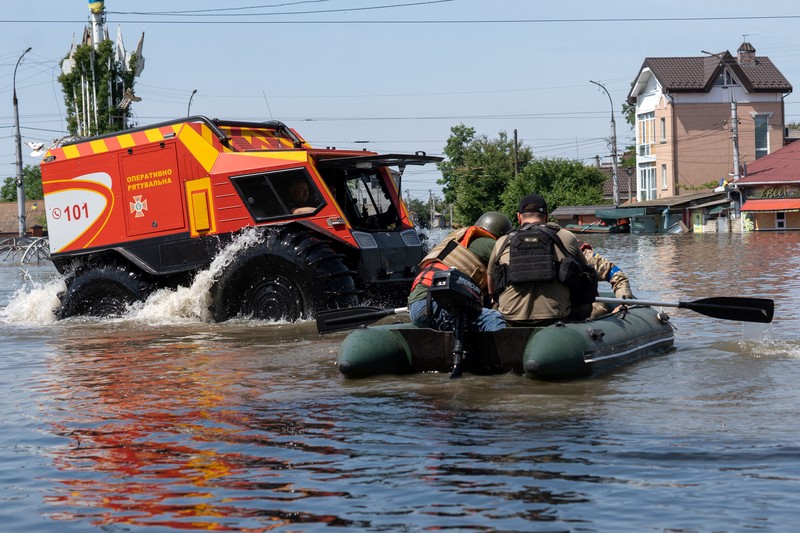 Tim penyelamat mengevakuasi seorang wanita dengan anjingnya di daerah banjir kota pada 7 Juni 2023 di Kherson, Ukraina. Tim penyelamat mengevakuasi seorang wanita dengan anjingnya di daerah banjir kota pada 7 Juni 2023 di Kherson, Ukraina. Akibat rusaknya bendungan Kakhovka, sekitar 80 pemukiman, termasuk Kherson, terancam banjir. Pihak berwenang dan sukarelawan mulai mengevakuasi penduduk dari daerah berbahaya. (Yan Dobronosov/Global Images Ukraine via Getty Images)