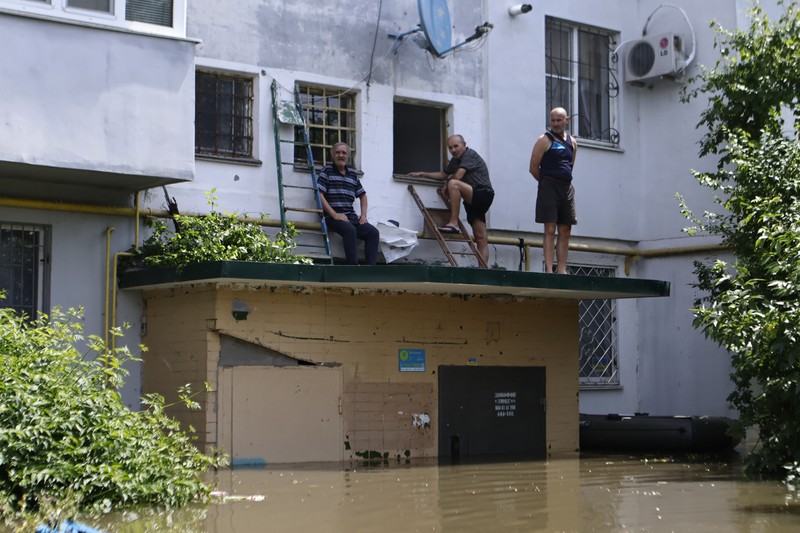 Tim penyelamat mengevakuasi seorang wanita dengan anjingnya di daerah banjir kota pada 7 Juni 2023 di Kherson, Ukraina. Tim penyelamat mengevakuasi seorang wanita dengan anjingnya di daerah banjir kota pada 7 Juni 2023 di Kherson, Ukraina. Akibat rusaknya bendungan Kakhovka, sekitar 80 pemukiman, termasuk Kherson, terancam banjir. Pihak berwenang dan sukarelawan mulai mengevakuasi penduduk dari daerah berbahaya. (Yan Dobronosov/Global Images Ukraine via Getty Images)