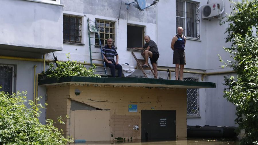 Tim penyelamat mengevakuasi seorang wanita dengan anjingnya di daerah banjir kota pada 7 Juni 2023 di Kherson, Ukraina. Akibat rusaknya bendungan Kakhovka, sekitar 80 pemukiman, termasuk Kherson, terancam banjir. Pihak berwenang dan sukarelawan mulai mengevakuasi penduduk dari daerah berbahaya. (Yan Dobronosov/Global Images Ukraine via Getty Images)