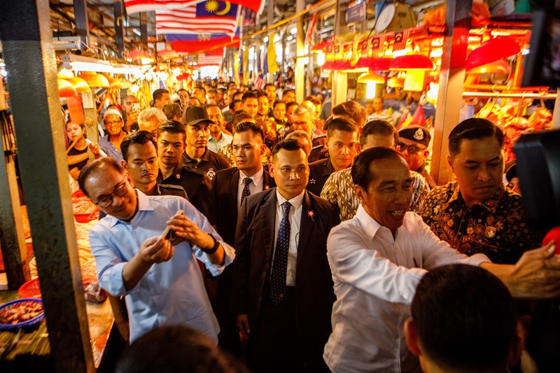 Presiden RI Jokowi - PM Malaysia Anwar Ibrahim Joko Widodo, Indonesia's president, center, and Anwar Ibrahim, Malaysia's prime minister, center left, visit a wet market in Kuala Lumpur, Malaysia, on Thursday, June 8, 2023. Malaysia and Indonesia resolved the yearslong maritime border disputes and signed six agreements on trade, border controls and migrant worker problems during Widodo's two-day visit to Kuala Lumpur. Photographer: Samsul Said/Bloomberg via Getty Images