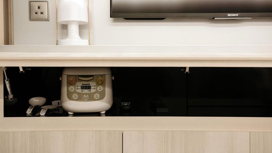 A rice cooker sits inside a cabinet at a Seven Victory Avenue micro-apartment show home, developed by Henderson Land Development Co., in Hong Kong, China, on Monday, Feb. 6, 2017. As Hong Kong's soaring prices put homes out of reach for most buyers, developers have been chopping new projects into ever-smaller units -- the tiniest category, below 200 square feet, is commonly referred to as nano flats. Photographer: Anthony Kwan/Bloomberg via Getty Images