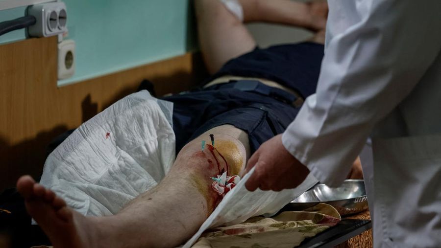 Emergency workers lay down during a Russian military strike while they evacuate people from a flooded area after the Nova Kakhovka dam breached, amid Russia's attack on Ukraine, during a Russian military strike in Kherson, Ukraine June 8, 2023. Ukrainian Presidential Press Service/Handout via REUTERS ATTENTION EDITORS - THIS IMAGE HAS BEEN SUPPLIED BY A THIRD PARTY.
