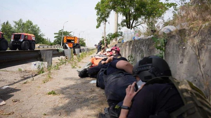 Emergency workers lay down during a Russian military strike while they evacuate people from a flooded area after the Nova Kakhovka dam breached, amid Russia's attack on Ukraine, during a Russian military strike in Kherson, Ukraine June 8, 2023. Ukrainian Presidential Press Service/Handout via REUTERS ATTENTION EDITORS - THIS IMAGE HAS BEEN SUPPLIED BY A THIRD PARTY.