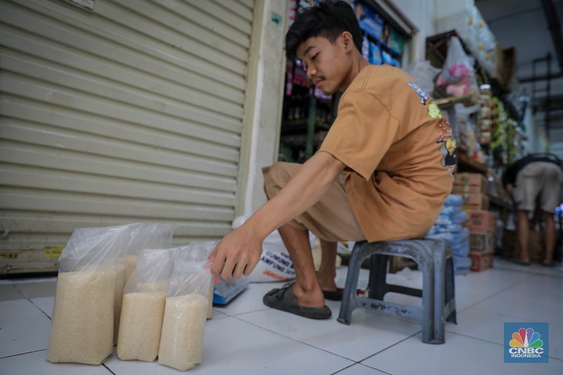 Pedagang menimbang dan mengemas gula pasir di Pasar Rumput, Jakarta, Jumat (9/6/2023). Harga gula pasir di Pasar Rumput rata-rata dijual dengan harga Rp15 ribu per kilogram. (CNBC Indonesia/Faisal Rahman)