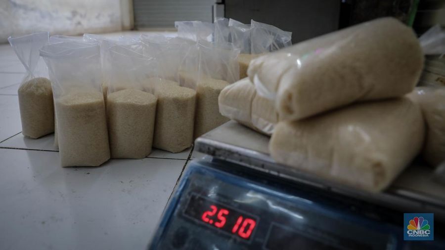 Pedagang menimbang dan mengemas gula pasir di Pasar Rumput, Jakarta, Jumat (9/6/2023). Harga gula pasir di Pasar Rumput rata-rata dijual dengan harga Rp15 ribu per kilogram. (CNBC Indonesia/Faisal Rahman)