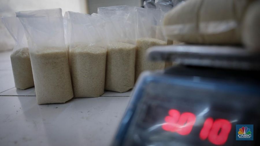 Pedagang menimbang dan mengemas gula pasir di Pasar Rumput, Jakarta, Jumat (9/6/2023). Harga gula pasir di Pasar Rumput rata-rata dijual dengan harga Rp15 ribu per kilogram. (CNBC Indonesia/Faisal Rahman)