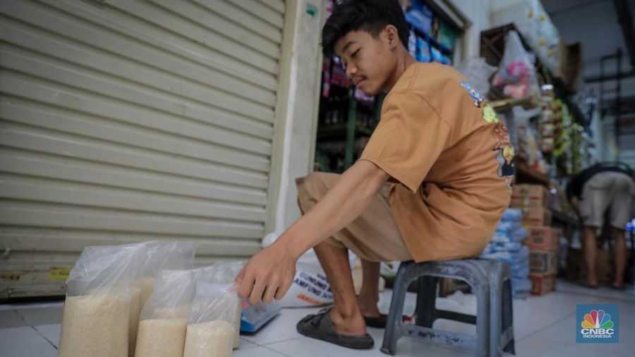 Pedagang menimbang dan mengemas gula pasir di Pasar Rumput, Jakarta, Jumat (9/6/2023). Harga gula pasir di Pasar Rumput rata-rata dijual dengan harga Rp15 ribu per kilogram. (CNBC Indonesia/Faisal Rahman)