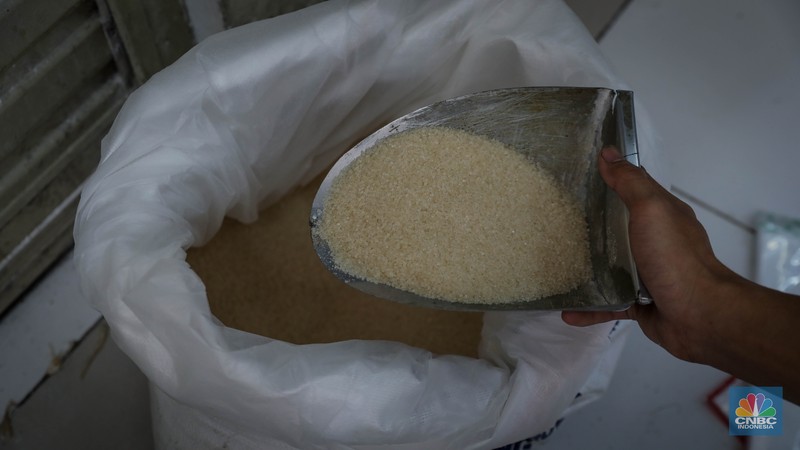 Pedagang menimbang dan mengemas gula pasir di Pasar Rumput, Jakarta, Jumat (9/6/2023). Harga gula pasir di Pasar Rumput rata-rata dijual dengan harga Rp15 ribu per kilogram. (CNBC Indonesia/Faisal Rahman)