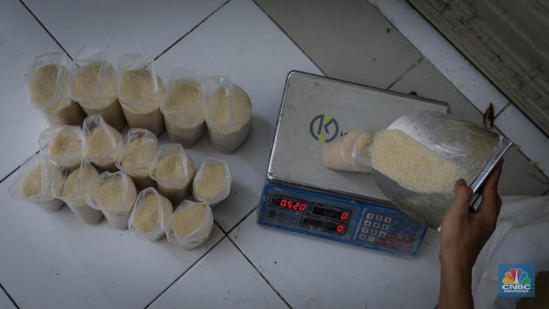Pedagang menimbang dan mengemas gula pasir di Pasar Rumput, Jakarta, Jumat (9/6/2023). Harga gula pasir di Pasar Rumput rata-rata dijual dengan harga Rp15 ribu per kilogram. (CNBC Indonesia/Faisal Rahman)