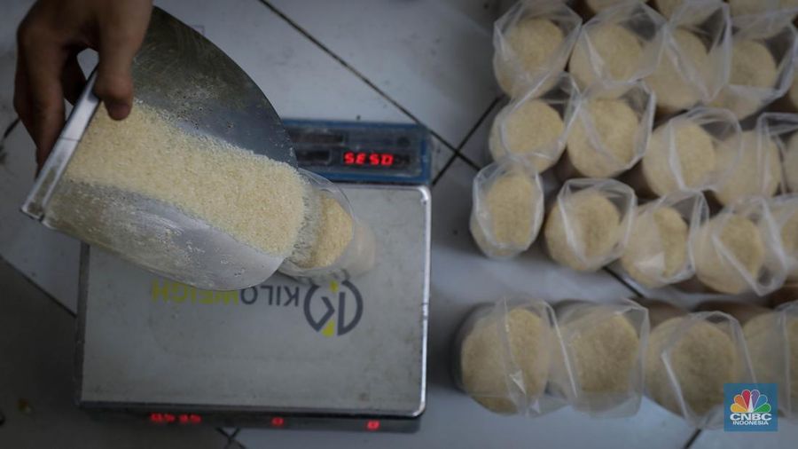 Pedagang menimbang dan mengemas gula pasir di Pasar Rumput, Jakarta, Jumat (9/6/2023). Harga gula pasir di Pasar Rumput rata-rata dijual dengan harga Rp15 ribu per kilogram. (CNBC Indonesia/Faisal Rahman)