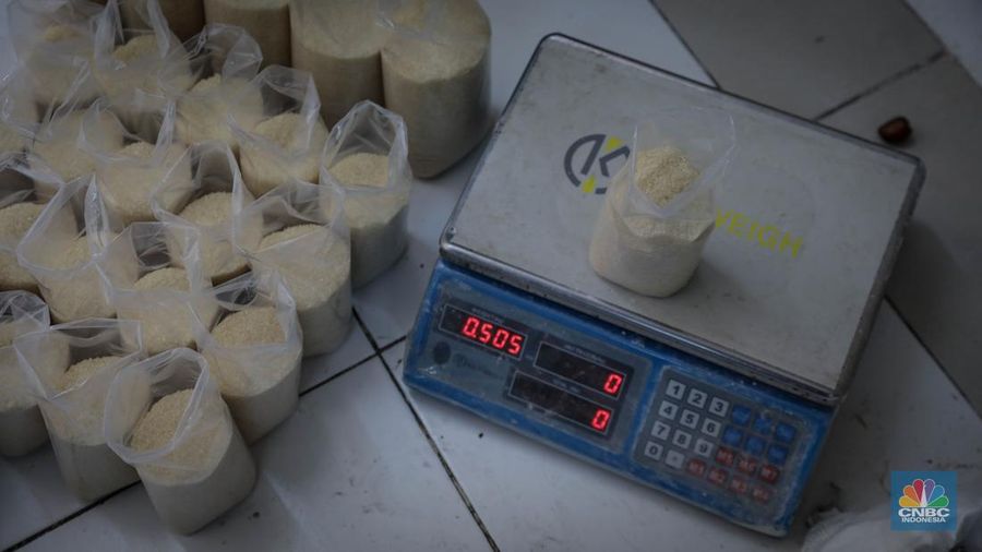 Pedagang menimbang dan mengemas gula pasir di Pasar Rumput, Jakarta, Jumat (9/6/2023). Harga gula pasir di Pasar Rumput rata-rata dijual dengan harga Rp15 ribu per kilogram. (CNBC Indonesia/Faisal Rahman)
