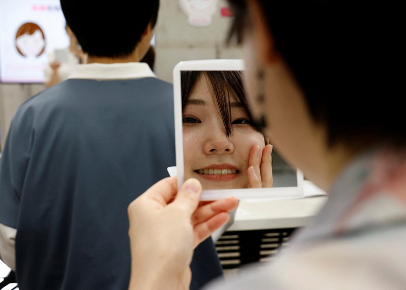 JAPAN-SMILE LESSONS/ Students practice smiling at a smile training course at Sokei Art School in Tokyo, Japan, May 30, 2023. REUTERS/Kim Kyung-Hoon