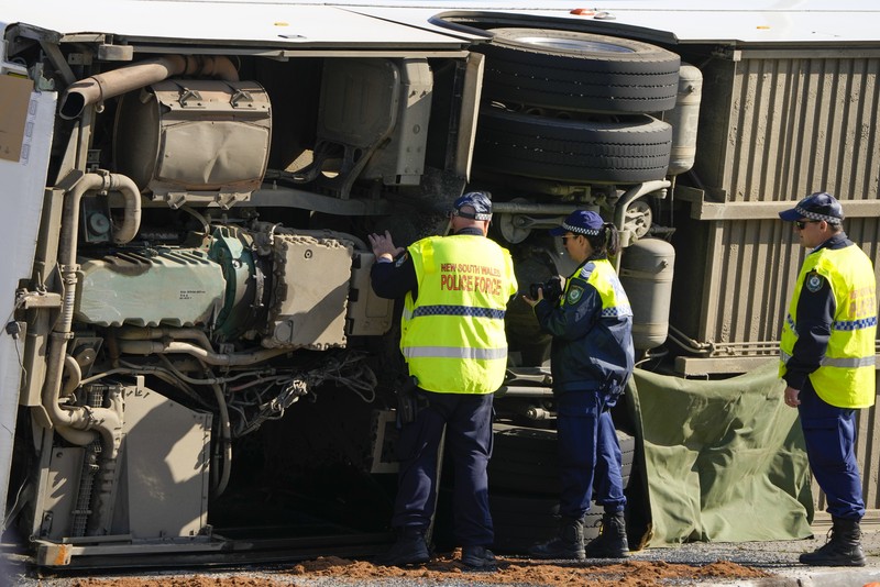Polisi memeriksa sebuah bus di sisinya dekat kota Greta setelah kecelakaan di Hunter Valley, utara Sydney, Australia, Senin, 12 Juni 2023. Polisi memeriksa sebuah bus di sisinya dekat kota Greta setelah kecelakaan di Hunter Valley, utara Sydney, Australia, Senin, 12 Juni 2023. Bus yang membawa tamu pernikahan terguling pada malam berkabut di negara penghasil anggur Australia, menewaskan dan melukai banyak orang, kata polisi. (AP Photo/Mark Baker)
