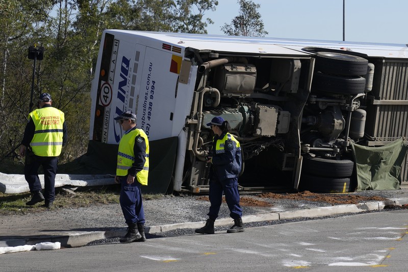 Polisi memeriksa sebuah bus di sisinya dekat kota Greta setelah kecelakaan di Hunter Valley, utara Sydney, Australia, Senin, 12 Juni 2023. Polisi memeriksa sebuah bus di sisinya dekat kota Greta setelah kecelakaan di Hunter Valley, utara Sydney, Australia, Senin, 12 Juni 2023. Bus yang membawa tamu pernikahan terguling pada malam berkabut di negara penghasil anggur Australia, menewaskan dan melukai banyak orang, kata polisi. (AP Photo/Mark Baker)