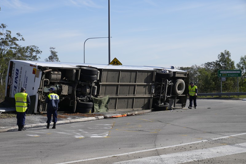Polisi memeriksa sebuah bus di sisinya dekat kota Greta setelah kecelakaan di Hunter Valley, utara Sydney, Australia, Senin, 12 Juni 2023. Polisi memeriksa sebuah bus di sisinya dekat kota Greta setelah kecelakaan di Hunter Valley, utara Sydney, Australia, Senin, 12 Juni 2023. Bus yang membawa tamu pernikahan terguling pada malam berkabut di negara penghasil anggur Australia, menewaskan dan melukai banyak orang, kata polisi. (AP Photo/Mark Baker)