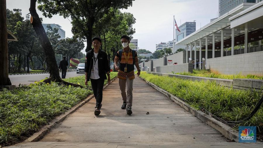 Indonesian Sejumlah warga melintasi trotoar jalan di depan Kedutaan Besar Amerika Serikat (Kedubes AS) di Jalan Merdeka Selatan, Jakarta, Selasa (13/6/2023). (CNBC Indonesia/Faisal Rahman)