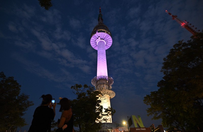 Menara Namsan Seoul yang terkenal diterangi dengan warna ungu untuk merayakan ulang tahun ke-10 debut megabintang K-pop BTS di Seoul pada 12 Juni 2023. (JUNG YEON-JE/AFP via Getty Images)