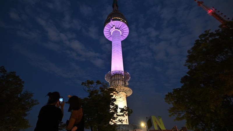 Menara Namsan Seoul yang terkenal diterangi dengan warna ungu untuk merayakan ulang tahun ke-10 debut megabintang K-pop BTS di Seoul pada 12 Juni 2023. (JUNG YEON-JE/AFP via Getty Images)
