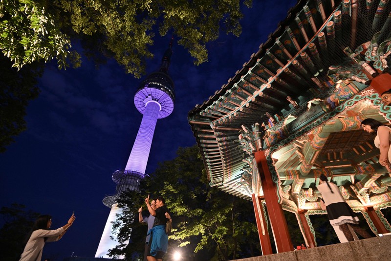 Menara Namsan Seoul yang terkenal diterangi dengan warna ungu untuk merayakan ulang tahun ke-10 debut megabintang K-pop BTS di Seoul pada 12 Juni 2023. (JUNG YEON-JE/AFP via Getty Images)