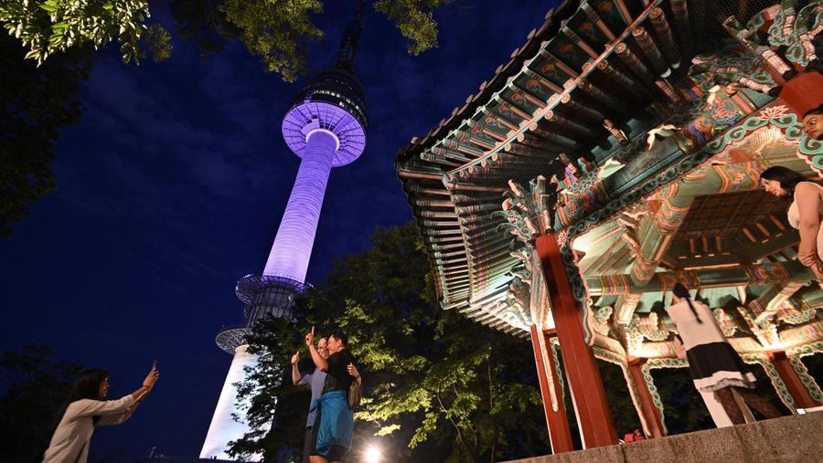 Menara Namsan Seoul yang terkenal diterangi dengan warna ungu untuk merayakan ulang tahun ke-10 debut megabintang K-pop BTS di Seoul pada 12 Juni 2023. (JUNG YEON-JE/AFP via Getty Images)