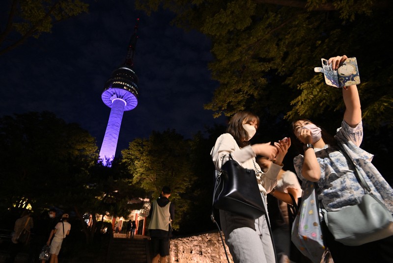 Menara Namsan Seoul yang terkenal diterangi dengan warna ungu untuk merayakan ulang tahun ke-10 debut megabintang K-pop BTS di Seoul pada 12 Juni 2023. (JUNG YEON-JE/AFP via Getty Images)