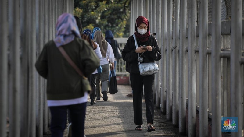 Warga berjalan melintasi Trotoar di kawasan Jalan M.H. Thamrin, Jakarta, Selasa (13/6/2023). Pemerintah resmi mengeluarkan aturan bebas masker pada ruang publik dan transportasi umum. (CNBC Indonesia/Faisal Rahman)