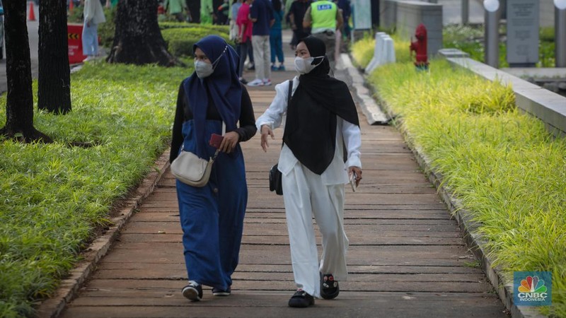 Warga berjalan melintasi Trotoar di kawasan Jalan M.H. Thamrin, Jakarta, Selasa (13/6/2023). Pemerintah resmi mengeluarkan aturan bebas masker pada ruang publik dan transportasi umum. (CNBC Indonesia/Faisal Rahman)