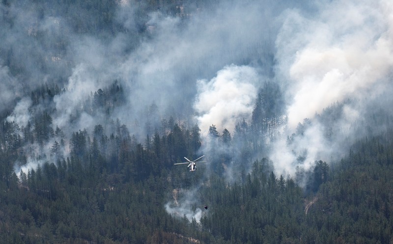 Sebuah helikopter terbang di tengah asap di atas sabuk hutan selama operasi untuk menahan kebakaran hutan di wilayah Abai timur, Kazakhstan, 12 Juni 2023. Sebuah helikopter terbang di tengah asap di atas sabuk hutan selama operasi untuk menahan kebakaran hutan di wilayah Abai timur, Kazakhstan, 12 Juni 2023. (REUTERS/Turar Kazangapov)