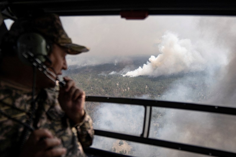 Sebuah helikopter terbang di tengah asap di atas sabuk hutan selama operasi untuk menahan kebakaran hutan di wilayah Abai timur, Kazakhstan, 12 Juni 2023. Sebuah helikopter terbang di tengah asap di atas sabuk hutan selama operasi untuk menahan kebakaran hutan di wilayah Abai timur, Kazakhstan, 12 Juni 2023. (REUTERS/Turar Kazangapov)