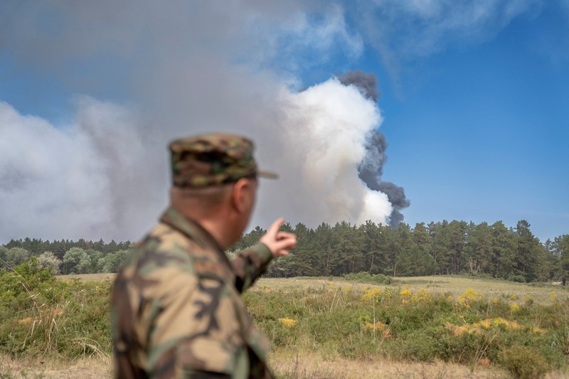 Sebuah helikopter terbang di tengah asap di atas sabuk hutan selama operasi untuk menahan kebakaran hutan di wilayah Abai timur, Kazakhstan, 12 Juni 2023. (REUTERS/Turar Kazangapov)