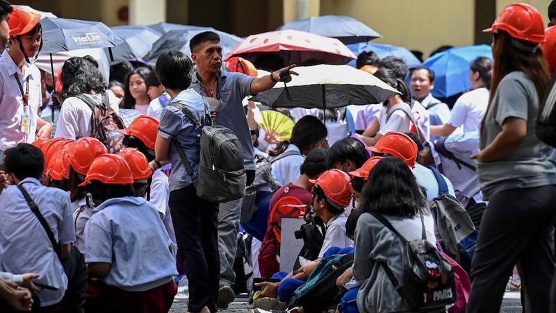 Siswa dan pekerja berhamburan keluar gedung saat gempa berkekuatan 6,2 magnitudo melanda Filipina, Kamis (15/6/2023). (AFP/JAM STA ROSA)