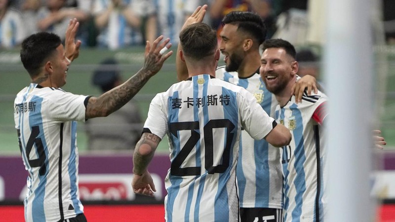 Pezzela Jerman Argentina, kiri, merayakan dengan Enzo Fernandez, tengah, dan Lionel Messi, kanan, setelah mencetak gol dalam pertandingan sepak bola persahabatan mereka melawan Australia di Stadion Pekerja di Beijing, China, Kamis, 15 Juni 2023. (AP Photo/Andy Wong)