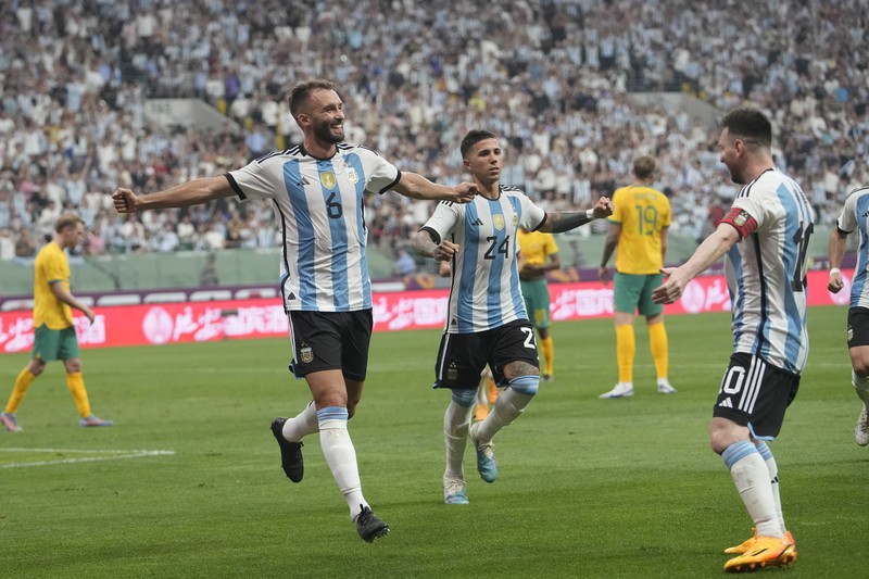 Pezzela Jerman Argentina, kiri, merayakan dengan Enzo Fernandez, tengah, dan Lionel Messi, kanan, setelah mencetak gol dalam pertandingan sepak bola persahabatan mereka melawan Australia di Stadion Pekerja di Beijing, China, Kamis, 15 Juni 2023. Pezzela Jerman Argentina, kiri, merayakan dengan Enzo Fernandez, tengah, dan Lionel Messi, kanan, setelah mencetak gol dalam pertandingan sepak bola persahabatan mereka melawan Australia di Stadion Pekerja di Beijing, China, Kamis, 15 Juni 2023. (AP Photo/Andy Wong)
