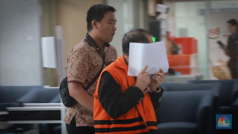 Terdakwa kasus suap pengurusan perkara di Mahkamah Agung (MA) Heryanto Tanaka menutupi wajahnya usai mengikuti sidang secara virtual di Gedung Merah Putih KPK, Jakarta, Jumat (16/6/2023).  (CNBC Indonesia/Muhammad Sabki)