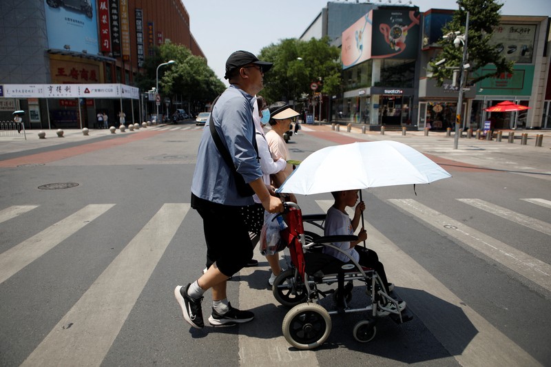 Seorang pejalan kaki melindungi dirinya dari sinar matahari saat melintasi jalan di hari yang panas di tengah peringatan oranye untuk gelombang panas, di Beijing, China 16 Juni 2023. Seorang pejalan kaki melindungi dirinya dari sinar matahari saat melintasi jalan di hari yang panas di tengah peringatan oranye untuk gelombang panas, di Beijing, China 16 Juni 2023. (REUTERS/Florence Lo)