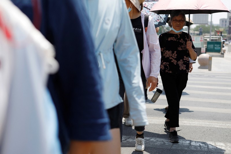 Seorang pejalan kaki melindungi dirinya dari sinar matahari saat melintasi jalan di hari yang panas di tengah peringatan oranye untuk gelombang panas, di Beijing, China 16 Juni 2023. Seorang pejalan kaki melindungi dirinya dari sinar matahari saat melintasi jalan di hari yang panas di tengah peringatan oranye untuk gelombang panas, di Beijing, China 16 Juni 2023. (REUTERS/Florence Lo)