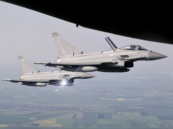 Jet tempur Eurofighter Typhoon Angkatan Udara Kerajaan mengawal sebuah pesawat angkut, di atas Rumania timur, Jumat, 27 April 2018. Skuadron Inggris yang terdiri dari empat jet tempur dan 160 personel menerima sertifikasi resmi untuk misi polisi udar