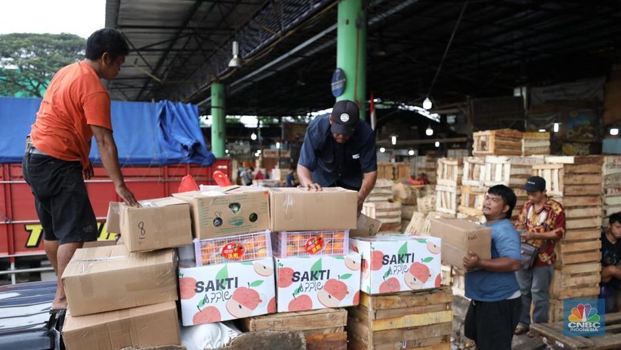 Pekerja melakukan bongkar muat buah impor dari China yang akan dipasarkan di Pasar Induk Kramat Jati, Jakarta, Senin (19/6/2023). (CNBC Indonesia/Tri Susilo)