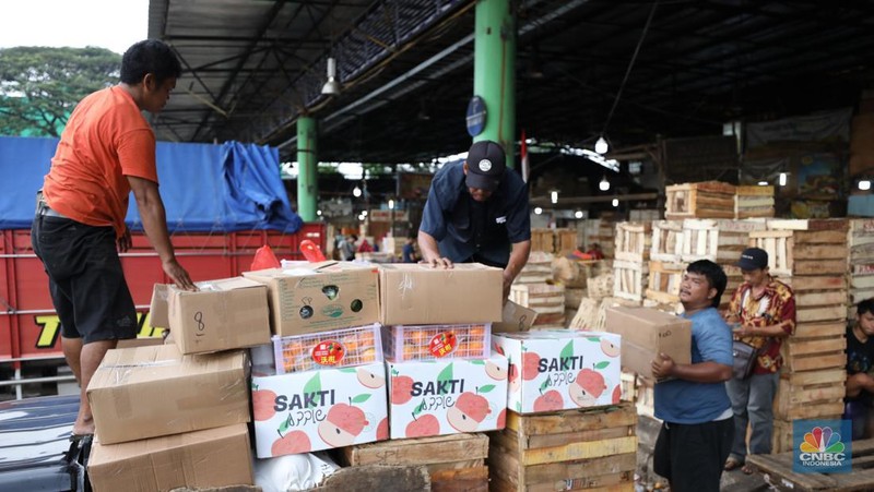 Pekerja melakukan bongkar muat buah impor dari China yang akan dipasarkan di Pasar Induk Kramat Jati, Jakarta, Senin (19/6/2023). (CNBC Indonesia/Tri Susilo)