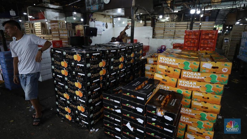 Pekerja melakukan bongkar muat buah impor dari China yang akan dipasarkan di Pasar Induk Kramat Jati, Jakarta, Senin (19/6/2023). (CNBC Indonesia/Tri Susilo)