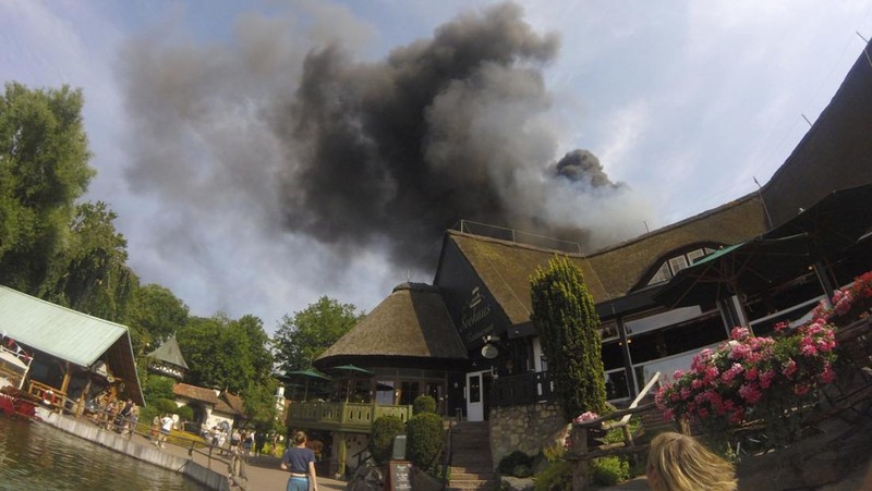 Pengunjung melihat asap yang mengepul di atas 'Europa-Park' di Rust, Jerman, Senin, 19 Juni 2023. Kebakaran besar terjadi di sebuah taman hiburan di barat daya Jerman, dengan asap hitam besar terlihat dari jauh. (zema-medien/dpa via AP)
