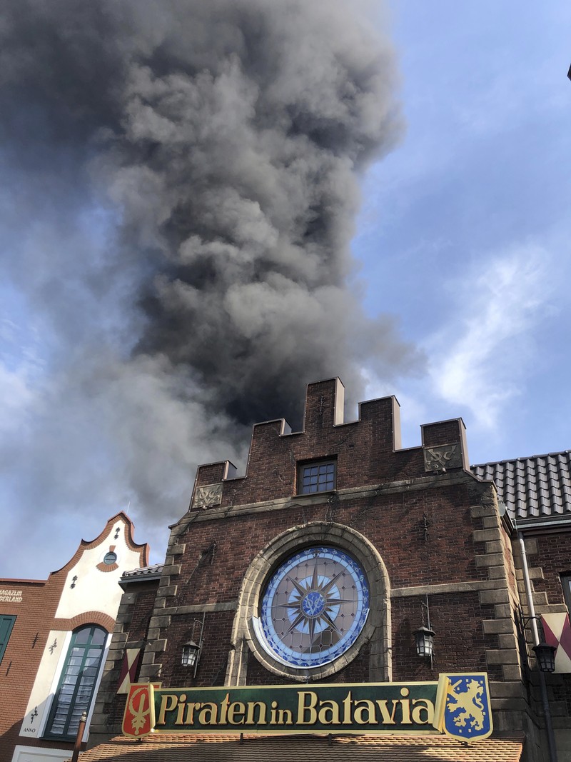Pengunjung melihat asap yang mengepul di atas 'Europa-Park' di Rust, Jerman, Senin, 19 Juni 2023. Kebakaran besar terjadi di sebuah taman hiburan di barat daya Jerman, dengan asap hitam besar terlihat dari jauh. (zema-medien/dpa via AP)