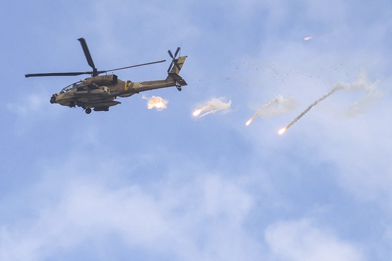 Helikopter serang AH-64 Apache Angkatan Udara Israel melepaskan suar selama serangan tentara Israel di Jenin di Tepi Barat yang diduduki pada 19 Juni 2023. Bentrokan kekerasan meletus di Jenin pada 19 Juni selama serangan Israel di kota Tepi Barat di mana tentara menembakkan rudal dari sebuah helikopter, menurut seorang fotografer AFP di tempat kejadian. (Jaafar ASHTIYEH / AFP)