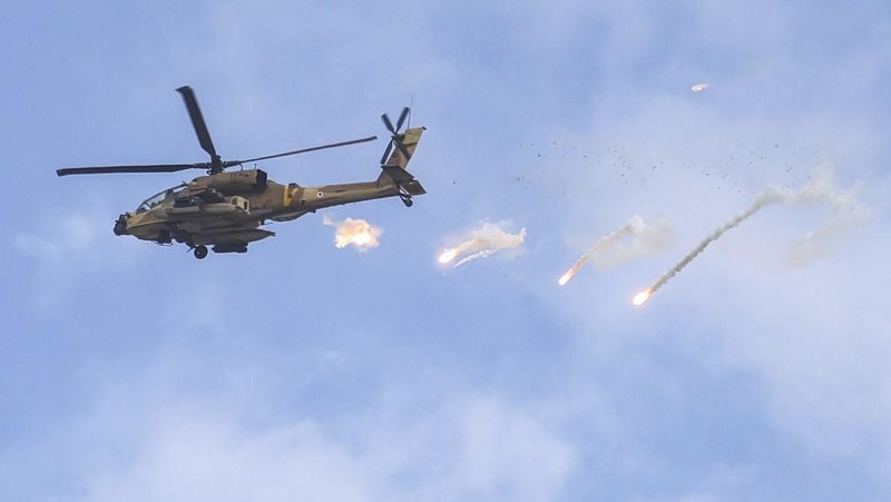 Helikopter serang AH-64 Apache Angkatan Udara Israel melepaskan suar selama serangan tentara Israel di Jenin di Tepi Barat yang diduduki pada 19 Juni 2023. Bentrokan kekerasan meletus di Jenin pada 19 Juni selama serangan Israel di kota Tepi Barat di mana tentara menembakkan rudal dari sebuah helikopter, menurut seorang fotografer AFP di tempat kejadian. (Jaafar ASHTIYEH / AFP)